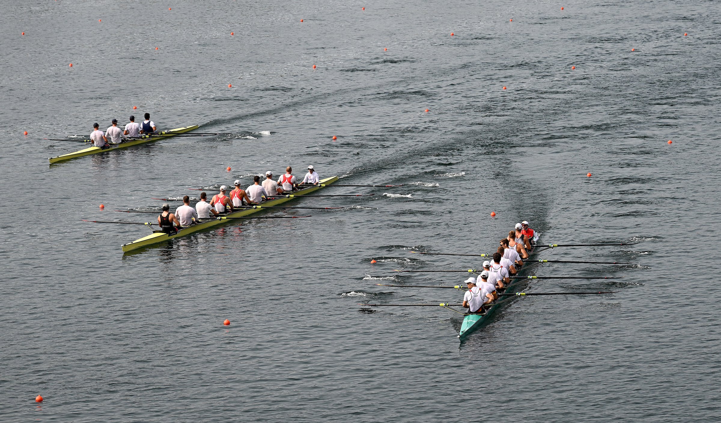 Rowing teams compete in a race on open water